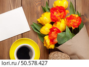 Colorful tulips bouquet, blank greeting card and coffee cup on wooden table. Стоковое фото, агентство Ingram Publishing / Фотобанк Лори