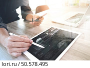 Website designer working digital tablet and computer laptop and digital design diagram on wooden desk as concept. Стоковое фото, агентство Ingram Publishing / Фотобанк Лори