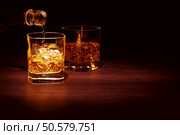 Single Malt Whiskey in a glass on a wooden table top.. Single Malt Whiskey. Стоковое фото, агентство Ingram Publishing / Фотобанк Лори
