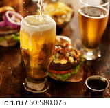 beer being poured into glass with gourmet hamburgers. Стоковое фото, агентство Ingram Publishing / Фотобанк Лори