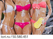 Beautiful bikini models wash a car on a summer day. Bikini Car Wash. Стоковое фото, агентство Ingram Publishing / Фотобанк Лори
