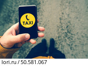 Using smartphone mobile app to call taxi, man dialing cab number on the street, top view, selective focus, retro tone filtered image. Стоковое фото, агентство Ingram Publishing / Фотобанк Лори