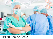 Hospital - surgery team in the operating room or Op of a clinic operating on a patient in emergency. Surgeons operating patient in operation theater. Стоковое фото, агентство Ingram Publishing / Фотобанк Лори