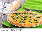 spinach cheese pie on white dish, piece of parmesan cheese and grater on wooden boards, view from above, close-up. Стоковое фото, агентство Ingram Publishing / Фотобанк Лори