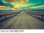 Perspective view of wooden pier over sea. Palanga city at sunset in autumn, Lithuania. Стоковое фото, агентство Ingram Publishing / Фотобанк Лори