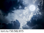 This dramatic photo illustration of a nighttime sky with brightly lit clouds and large, full, Blue Moon would make a great background for many uses.. Dramatic Nighttime Clouds and Sky With Beautiful Full Blue Moon. Стоковое фото, агентство Ingram Publishing / Фотобанк Лори