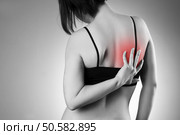 Woman with backache. Pain in the  human body. Black and white photo with red dot. Woman with backache. Pain in the human body. Стоковое фото, агентство Ingram Publishing / Фотобанк Лори