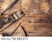 Od vintage hand tools on wooden background. Carpenter workplace.  Tinted photo. Стоковое фото, агентство Ingram Publishing / Фотобанк Лори