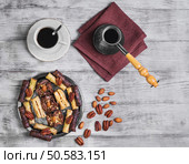Baklava walnut, chocolate, almonds, pecans on a round metal tray on a light wooden background, top view. Baklava walnut food. Стоковое фото, агентство Ingram Publishing / Фотобанк Лори