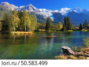  Lake with cold water surrounded by trees and snow-capped mountains. City park in the Alpine resort of Chamonix. Стоковое фото, агентство Ingram Publishing / Фотобанк Лори