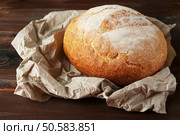 Fresh bread on paper on wooden background. Стоковое фото, агентство Ingram Publishing / Фотобанк Лори