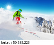 Freeride skier with rucksack running downhill in freeze motion of snow powder.. Freeride skier on piste running downhill. Стоковое фото, агентство Ingram Publishing / Фотобанк Лори
