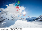 Freeride skier jumping from rock in freeze motion of snow powder.. Freeride skier jumping from rock. Стоковое фото, агентство Ingram Publishing / Фотобанк Лори