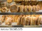 Lots of fresh bread loafs on a shelves of a bakery store. Bread loafs on a shelf. Стоковое фото, агентство Ingram Publishing / Фотобанк Лори
