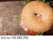 Bagels with Italian ham prosciutto, cream cheese, tomatoes and salad  on rustic metal tray with flowers. Top View. Стоковое фото, агентство Ingram Publishing / Фотобанк Лори