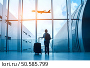 travel concept, woman in airport, passenger silhouette waiting with luggage in airport. Стоковое фото, агентство Ingram Publishing / Фотобанк Лори