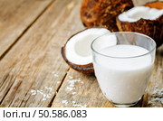 coconut milk and coconuts on a dark wood background. the toning. selective focus. Стоковое фото, агентство Ingram Publishing / Фотобанк Лори