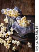 Prepared salted popcorn served in small buckets with paper inside on wood chopping board over dark wooden background.. Prepared salted popcorn. Стоковое фото, агентство Ingram Publishing / Фотобанк Лори