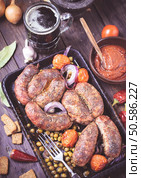 Homemade baked sausages with pea and tomatoes on table closeup. Toned. Стоковое фото, агентство Ingram Publishing / Фотобанк Лори
