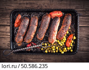 Homemade roasted sausages with pea and fork on table top view. Homemade sausages and fork top view. Стоковое фото, агентство Ingram Publishing / Фотобанк Лори