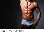 Muscular and sexy torso of young sport man with perfect abs in panties Man striptease. Front view. Muscular and sexy torso of young sport man with perfect abs in panties. Man striptease. Front view. Стоковое фото, агентство Ingram Publishing / Фотобанк Лори