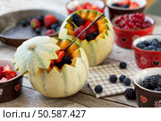 French melons filled with berries: blueberries, strawberries, blackberries and redcurrants.. French Melons Filled With Berries. Стоковое фото, агентство Ingram Publishing / Фотобанк Лори