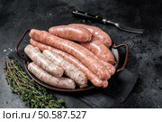 Sausages variation in steel tray. Raw Sausages with Beef, pork, lamb and chicken meat. Black background. Top view. Стоковое фото, агентство Ingram Publishing / Фотобанк Лори