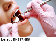 Young woman at the dentist’s chair during a dental procedure. Overview of dental caries prevention. Стоковое фото, агентство Ingram Publishing / Фотобанк Лори