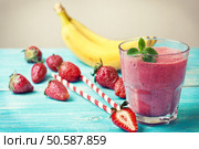 smoothie with banana and strawberry in the glass, fresh strawberries and bananas on the  wooden background (toning) Стоковое фото, агентство Ingram Publishing / Фотобанк Лори