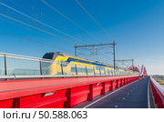 train passing the new red railroad bridge over the IJssel river in the Netherlands. Стоковое фото, агентство Ingram Publishing / Фотобанк Лори