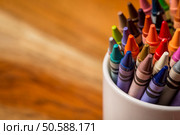 Crayons in a white mug sitting on a wooden desk. Стоковое фото, агентство Ingram Publishing / Фотобанк Лори