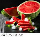  Seedless ripe watermelon cut slices with mint and ice on a black background. Стоковое фото, агентство Ingram Publishing / Фотобанк Лори