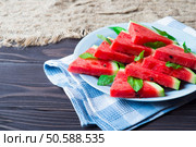 Slices of watermelon with mint leaves on blue ceramic plate. Стоковое фото, агентство Ingram Publishing / Фотобанк Лори