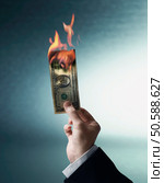 Businessman’s hand holding burning US Dollar. 24316758. Стоковое фото, агентство Ingram Publishing / Фотобанк Лори