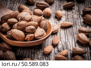 Almond nuts in mixing scoop on linen rustic background. Стоковое фото, агентство Ingram Publishing / Фотобанк Лори