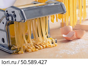 Preparation of homemade pasta spaghetti  on wooden background. Стоковое фото, агентство Ingram Publishing / Фотобанк Лори