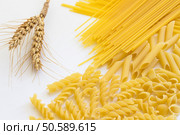 Spikelets of wheat and several types of pasta on a white background. Стоковое фото, агентство Ingram Publishing / Фотобанк Лори