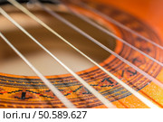Detail of classic acoustic guitar with shallow depth of field.. Detail of classic acoustic guitar with shallow DOF and blur. Стоковое фото, агентство Ingram Publishing / Фотобанк Лори