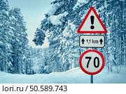 winter view on the road through coniferous forest. Road caution sign in forest landscape. road in snowy winter on beautiful sunny day. Стоковое фото, агентство Ingram Publishing / Фотобанк Лори