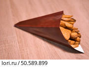 Potatoes wedges in paper cone. Стоковое фото, агентство Ingram Publishing / Фотобанк Лори