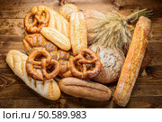 Bread, baguette, loaf and buns on the wooden desk. Bread, baguette, loaf and buns on the wooden desk. Horizontal. Стоковое фото, агентство Ingram Publishing / Фотобанк Лори