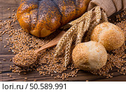 Plenty of sliced bread background. Bakery and grocery concept. Fresh, healthy whole grain sliced sorts of rye and white loaves, sprinkled flour on sackcloth and rustic wood table, food top view. Bakery concept. Plenty of sliced bread background. Стоковое фото, агентство Ingram Publishing / Фотобанк Лори