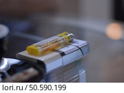 Pack of cigarettes and lighter on the glass table. Стоковое фото, агентство Ingram Publishing / Фотобанк Лори