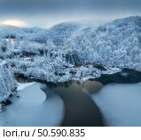 Aerial drone view of frozen lake, waterfall and snowy forest at sunset. Winter fairytale in Plitvice Lakes, Croatia. Top view of white snow-covered trees, waterfall, trails, fog, cloudy sky. Nature. Стоковое фото, агентство Ingram Publishing / Фотобанк Лори
