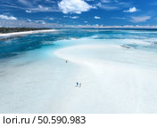 Aerial view of island during low tide, sandbank in ocean, white sandy beach, people, blue sea on sunny summer day in Zanzibar. Top view of sand spit, clear water, sky with clouds. Tropical background. Стоковое фото, агентство Ingram Publishing / Фотобанк Лори