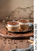 Indulge in a luscious tiramisu-inspired chia pudding, layered with creamy coffee-infused chia and a rich chocolate topping. A delightful breakfast or dessert option that combines classic tiramisu flavors with wholesome ingredients for a convenient and satisfying treat. Стоковое фото, агентство Ingram Publishing / Фотобанк Лори