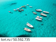 Aerial view of beautiful luxury yacht and boat in blue sea in summer. Sardinia, Italy. Top drone view of speed boat, sea bay, transparent turquoise water. Travel. Tropical colorful landscape. Yachting. Стоковое фото, агентство Ingram Publishing / Фотобанк Лори