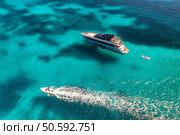 Aerial view of beautiful luxury yacht and speed boat in blue sea in summer. Sardinia, Italy. Top drone view of boat, sea bay, transparent azure water. Travel. Tropical colorful landscape. Yachting. Стоковое фото, агентство Ingram Publishing / Фотобанк Лори
