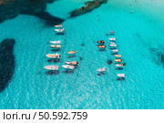 Aerial view of beautiful luxury yacht and boat in blue sea in summer. Sardinia, Italy. Top drone view of speed boat, sea bay, transparent turquoise water. Travel. Tropical colorful landscape. Yachting. Стоковое фото, агентство Ingram Publishing / Фотобанк Лори