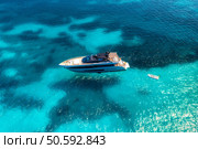 Aerial view of beautiful luxury yacht in blue sea in summer. Sardinia, Italy. Top drone view of boat, sea bay, transparent turquoise water. Travel and vacation. Tropical colorful landscape. Yachting. Стоковое фото, агентство Ingram Publishing / Фотобанк Лори